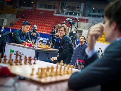Carlsen mira a Van Foreest poco antes de enfrentarse a Abdusattórov en el reciente Mundial de Rápidas en Almaty (Kazajistán)