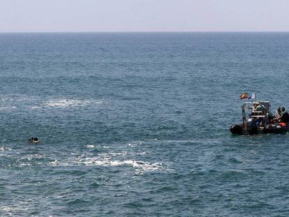 Dos submarinistas y una lancha de la Guardia Civil, durante la búsqueda de inmigrantes desaparecidos el pasado mayo al sur de Gran Canaria.