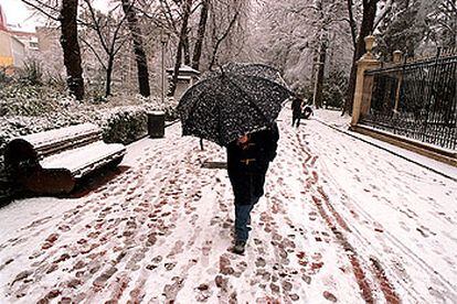 Una persona se protege con un paraguas, en Vitoria, de la fuerte tormenta de nieve que caía entonces.