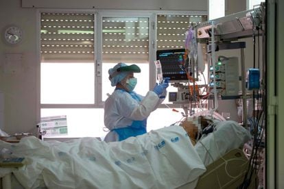 Un trabajador sanitario atiende a un paciente de coronavirus en una Unidad de Cuidados Intensivos del hospital Príncipe de Asturias de Alcalá de Henares (Madrid).