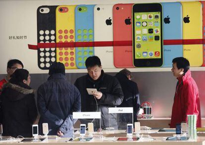 Varios clientes revisan dispositivos en una tienda de Apple en Pek&iacute;n.