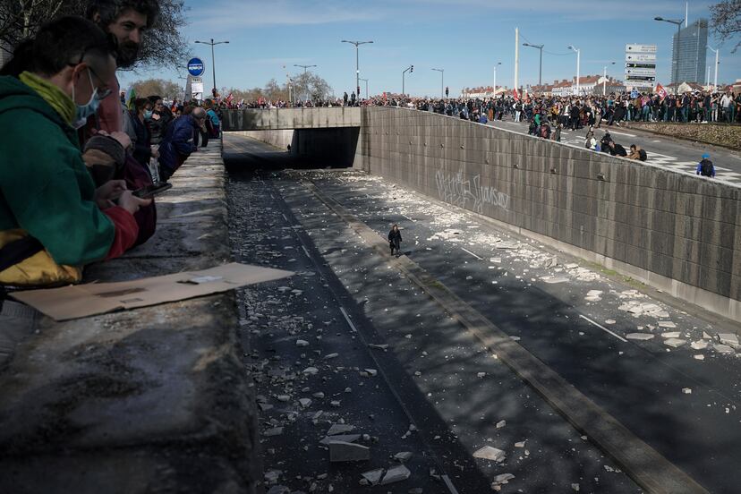 Una mujer camina por una carretera cortada al tráfico por los manifestantes, en Lyon.