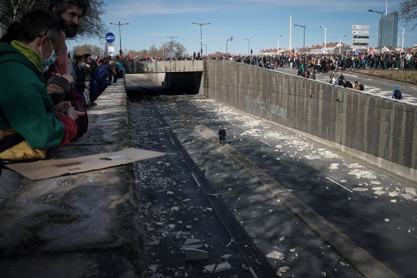 Una mujer camina por una carretera cortada al tráfico por los manifestantes, en Lyon. 