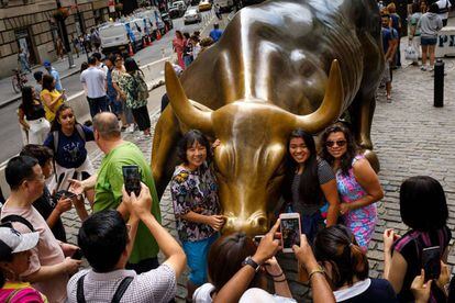 Turistas con la estatua del toro en Wall Street, Nueva York