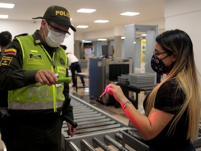 Un oficial revisa la identificación de una pasajera en el aeropuerto Olaya Herrera de Medellín (Colombia).