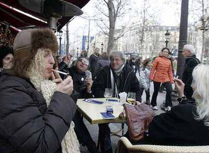 Varios turistas fuman el pasado día 1 de enero en una terraza de París.
