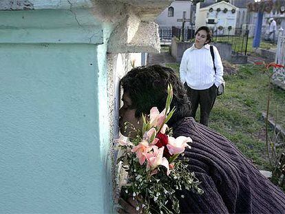 Rosa Franco besa la tumba de su hija María Isabel, acompañada de María Elena Peralta, hermana de otra víctima.