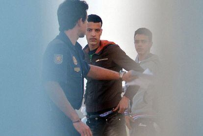 Un policía custodia a dos inmigrantes en el CIE de El Matorral, en Fuerteventura.