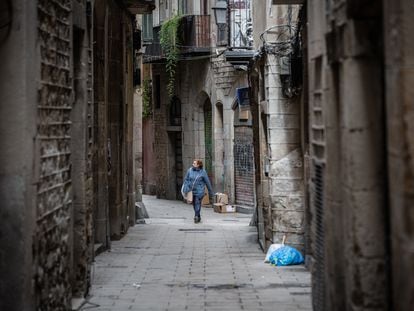 Una mujer anda por una calle de Barcelona durante el segundo día laborable del estado de alarma por el coronavirus, en Barcelona.