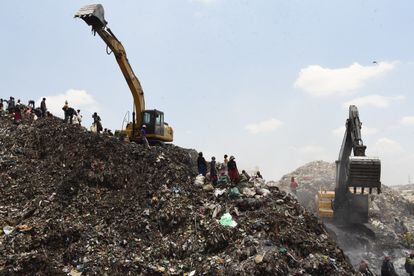 Una excavadora sobre una montaña de basura en el vertedero de Dandora.