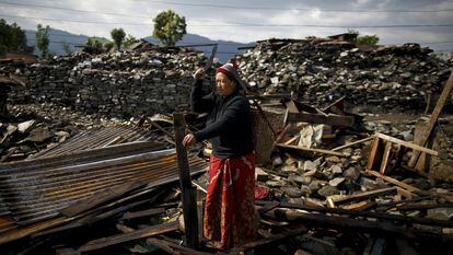 Una víctima del terremoto de Nepal (2015) corta la madera de los escombros de su casa en la aldea de Barpak, en el distrito de Gorkha.