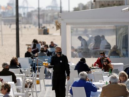 Un camarero atiende las mesas de una terraza en uno de los restaurantes de la playa de la playa de la Malvarrosa de Valencia el 15 de marzo.