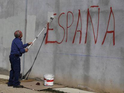 Una persona tapa una pintada contra Espanya.