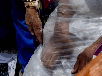 Las manos de don Luis Alfonso Ballén (59) y Marta Patricia Hilarión (61) embutiendo en una bolsa el plástico que recogieron en la calle y que venderán por menos de un euro.