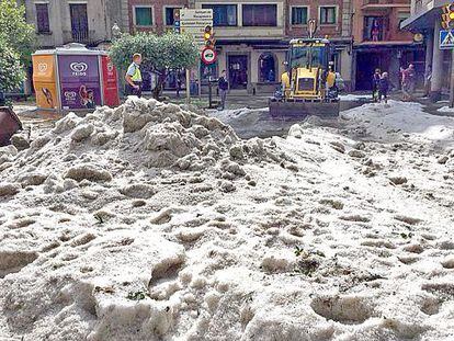 Una excavadora recoge el granizo, ayer por la tarde en Torell&oacute;.