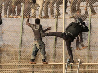 Un grupo de inmigrantes se enfrenta intenta sortear la valla de Melilla.