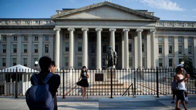 Washington (United States), 30/07/2011.- (FILE) - A tourist poses in front of the US Treasury Department in Washington, DC, USA, on 30 July 2011 (Reissued 13 December 2020). According to reports, hackers supported by a foreign government, most likely Russians, have hacked the US Treasury Department and the US Commerce Department's National Telecommunications and Information Administration. Various US intelligence agencies are investigating whether other federal agencies were hacked. (Rusia, Estados Unidos) EFE/EPA/BRENDAN SMIALOWSKI *** Local Caption *** 02849281