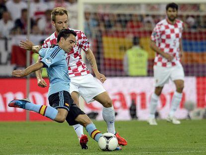 Xavi golpea el bal&oacute;n ante Rakitic durante el partido Croacia-Espa&ntilde;a.