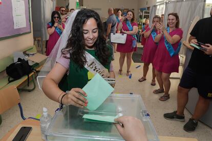 Una joven con velo y disfrazada para celebrar su despedida de soltera se dispone a introducir su papeleta de voto en una urna del IES La Caleta en el barrio de La Viña, en Cádiz.