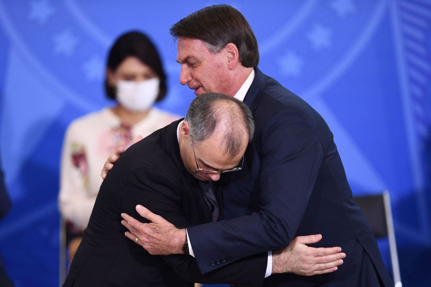 Bolsonaro abraza a su nuevo ministro de Justicia, André Mendonça, ante la mirada de la esposa del presidente, Michelle, en Brasilia este miércoles.