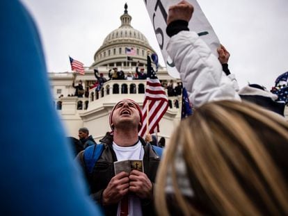 Un hombre reza en el exterior del Capitolio durante el asalto del 6 de enero de 2021.