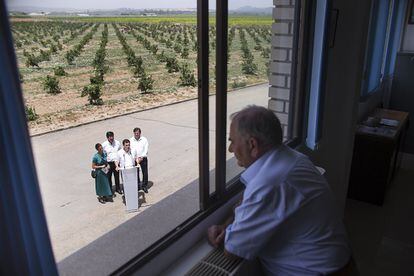 El líder nacional de Ciudadanos, Albert Rivera, durante su visita electoral el 9 de junio de 2016 a la finca Supra, en la localidad sevillana de Tocina, donde un vecino le observa desde la ventana durante su intervención.