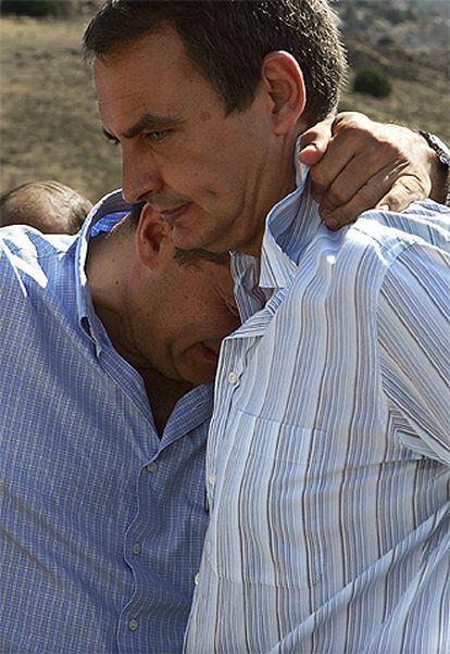 El alcalde de Abranque, Jose Miguel del Castillo, abraza a Zapatero durante su visita a la zona del incendio.