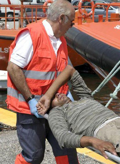 Personal sanitario atiende a uno de los 34 inmigrantes marroquíes llegados a Motril.