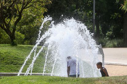 Dos niños se mojan en una fuente en el parque de Madrid Río, ese miércoles.