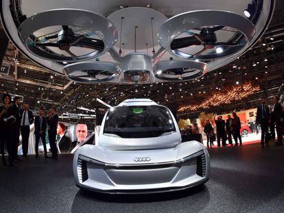 The "Pop.up next" concept flying car, a hybrid vehicle that blends a self-driving car and passenger drone by Audi, italdesign and Airbus is seen during the first press day of the Geneva International Motor Show on March 6, 2018 in Geneva.  The show opens to the public on March 8 and runs through March 18. / AFP PHOTO / Fabrice COFFRINI