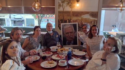 La familia de Juan José Fernández, comiendo en el Café Varela, uno de sus lugares predilectos, junto a su retrato el pasado mes de julio