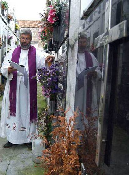 Luis Rodríguez Patiño, cura de Xestoso, con documentación parroquial en un cementerio.