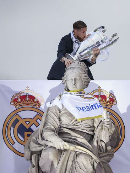 Sergio Ramos besa el trofeo mientras toca la fuente de la plaza de Cibeles