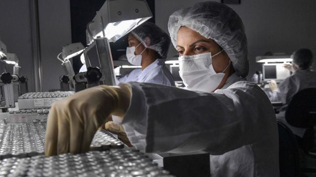 (FILES) In this file photo taken on January 14, 2021 employees work on the production line of CoronaVac, Sinovac Biotech's vaccine against the COVID-19 coronavirus at the Butantan biomedical production centre, in Sao Paulo, Brazil. - Shortages of COVID-19 vaccines have forced several large Brazilian cities to suspend administering second doses, officials and media reports said on May 3, 2021, the latest breakdown in the hard-hit country's troubled immunization drive. Seven of Brazil's 26 state capitals have stopped administering the booster shot of Chinese-developed CoronaVac because of a lack of supply, according to news site G1. (Photo by NELSON ALMEIDA / AFP)