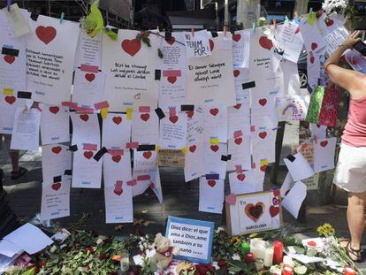 Una mujer cuelga un mensaje de homenaje a las v&iacute;ctimas del atentado de Barcelona. 