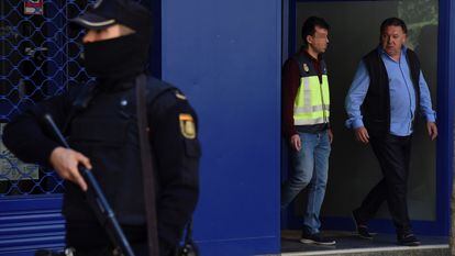 El presidente del Huesca, Agustín Lasaosa, junto a un policía a su salida de las oficinas del club tras ser detenido durante la "Operación Oikos" contra el presunto amaño de partidos de fútbol en Primera y Segunda División en 2019.