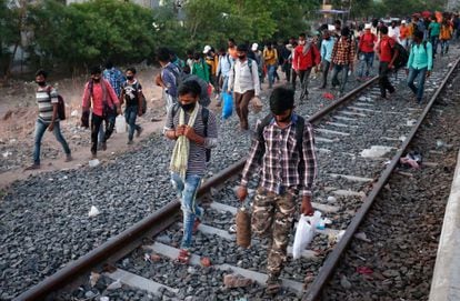 Decenas de trabajadores migrantes caminan junto a una vía del tren en Ahmedabad para volver a su ciudad de origen, en mayo de 2020. 