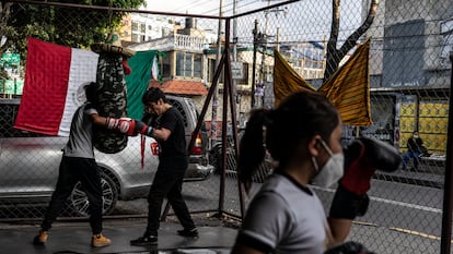 Una niña y dos jóvenes entrenan boxeo en una escuela ubicada en un bajopuente en Azcapotzalco, Ciudad de México, el 9 de septiembre de 2021.