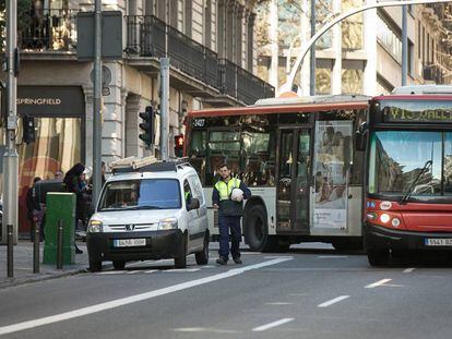 Un autobús supera una furgoneta aparcada en la ciudad de Barcelona.