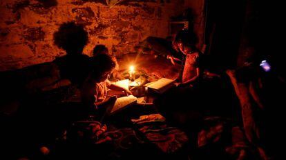 Menores hacen sus deberes durante un corte de luz en una zona empobrecida de Gaza, en 2011.
