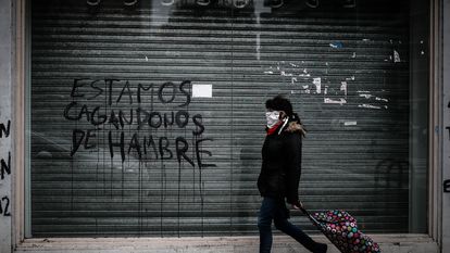 Una mujer pasa delante de un local cerrado por la crisis económica en Buenos Aires, en junio de 2020.