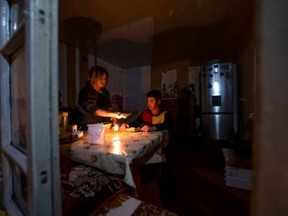 Una mujer y su hijo cenan en su casa de Stepanakert a la luz de una vela tras los cortes de electricidad por el bloqueo de Azerbaiyán al enclave armenio de Nagorno Karabaj, el pasado 18 de enero.