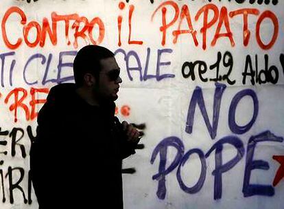 Un estudiante pasa junto a las pintadas contra la visita del Papa a la Universidad de La Sapienza, de Roma.