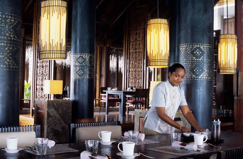 Una camarera arregla una de las mesas del restaurante Reethi, en el complejo hotelero One & Only Reethi Rah Hotel.