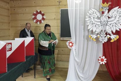Una mujer vestida con el traje tradicional vota en un colegio eletoral en Zakopane.