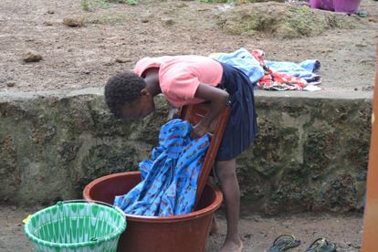 Lucy, une fille qui a été enlevée de son village sous la promesse d'une meilleure éducation pour la transformer en esclave, lave ses vêtements dans le refuge salésien de l'ONG Don Bosco Fambul, à Freetown.
