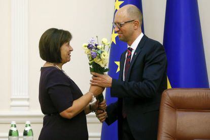 Yatseniuk (R) da un ramo de flores a su ministra de Finanzas.