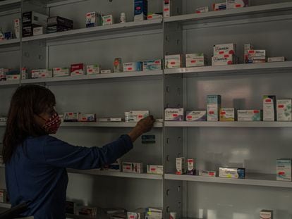 Una empleada acomoda medicamentos en una farmacia privada en Ciudad de México.