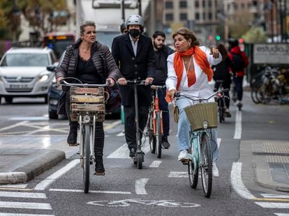 Two women pedal along a bike lane in Valencia. 