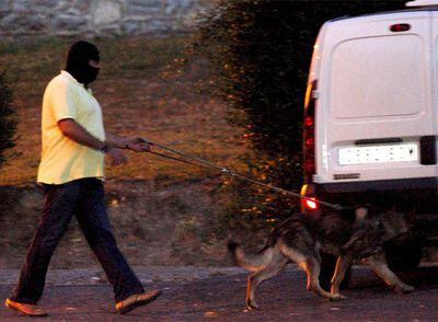 Un agente se dirige con un perro adiestrado al cementerio de Berango, donde se halló un <i>buzón</i> de ETA.